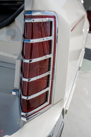 Téléchargez les photos : Gros plan des feux arrière vintage de style rétro sur une voiture de luxe blanche. - en image libre de droit