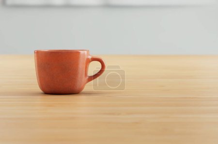 Téléchargez les photos : Tasse à café en 3D orange sur comptoir en bois avec fond blanc. - en image libre de droit