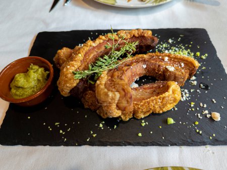 Photo for Typical Spanish dish called torreznos, consisting of deep-fried pork skin and savory fried crust - Royalty Free Image