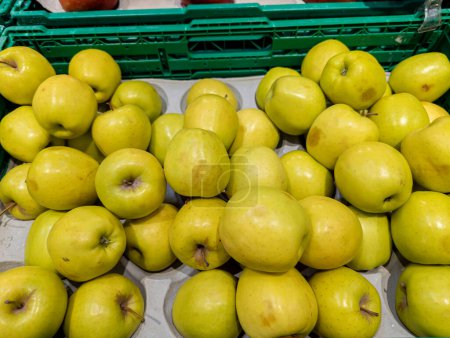 Foto de Manzanas doradas en un mercado, caja con manzanas frescas para la venta, alimentación saludable - Imagen libre de derechos
