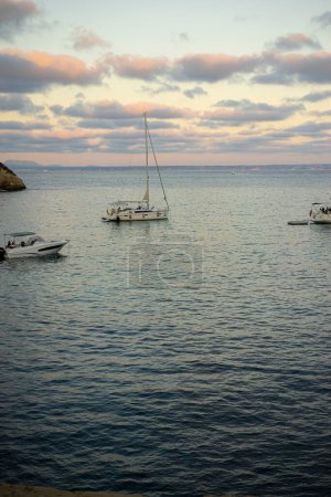 Photo for As evening descends, boats in a Mallorca cove paint a picturesque scene, symbolizing the island's allure and the romance of Spanish sunsets. - Royalty Free Image