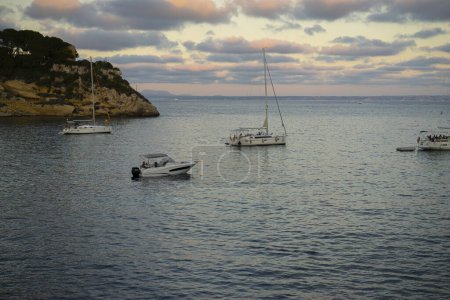 Téléchargez les photos : Vivez la romance de Majorque alors que les bateaux mouillent dans une crique côtière, embrassés par les derniers rayons du soleil, mettant en valeur le charme idyllique de l'île. - en image libre de droit