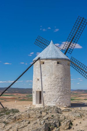Téléchargez les photos : Moulins à vent perchés, silhouette contre le ciel espagnol. L'histoire, la culture et la beauté des paysages de Tolède entrelacés dans un même cadre - en image libre de droit