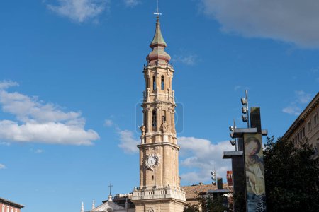 Primer plano de la torre del reloj de la Basílica del Pilar, una fusión de arquitectura histórica y funcional contra un cielo sereno.
