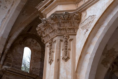 Nahaufnahme einer korinthischen Säule mit kunstvollen Kapitellen in den Ruinen des Monasterio de Piedra, die reiche architektonische Details aufweist.