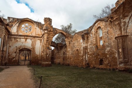 Photo for A vertical shot capturing the intricate facade of the weathered ruins of the Monasterio de Piedra's church against a cloudy sky. - Royalty Free Image
