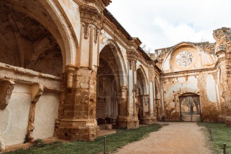 Tonos cálidos envuelven los majestuosos arcos y rosetones del claustro del Monasterio de Piedra, irradiando grandeza histórica.
