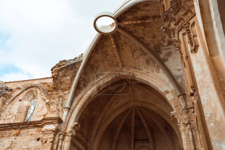 Des tons chauds enveloppent les majestueuses arches et rosettes du cloître du Monasterio de Piedra, rayonnant de grandeur historique.