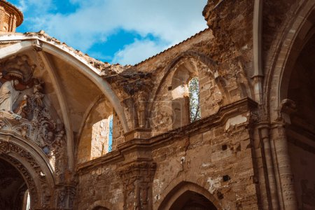 Warm tones envelop the majestic arches and rosette window of the Monasterio de Piedra's cloister, radiating with historical grandeur.