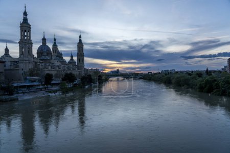 Photo for Twilight view of Basilica de Nuestra Seora del Pilar beside the Ebro River in Zaragoza, with illuminated fasades. - Royalty Free Image
