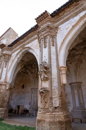 Nahaufnahme einer korinthischen Säule mit kunstvollen Kapitellen in den Ruinen des Monasterio de Piedra, die reiche architektonische Details aufweist.