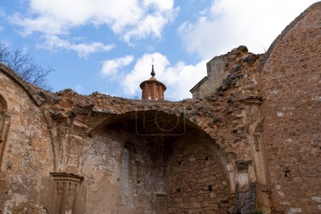 Foto de Un disparo vertical que captura la intrincada fachada de las ruinas erosionadas de la iglesia del Monasterio de Piedra contra un cielo nublado. - Imagen libre de derechos