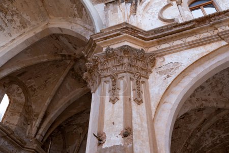 Gros plan d'une colonne corinthienne avec des chapiteaux ornés dans les ruines de Monasterio de Piedra, montrant de riches détails architecturaux.