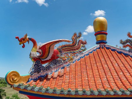 Téléchargez les photos : Détail du toit de Viharn Sien, un musée et sanctuaire chinois-thaïlandais près de Wat Yan à Huai Yai, près de Pattaya, province de Chonburi en Thaïlande. L'oiseau est le mythique Feng, fenghuang ou huang (phénix). - en image libre de droit