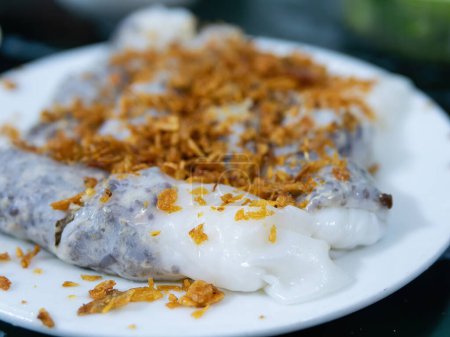 Photo for Banh cuon, rice sheet rolls with minced pork, garnished with hanh phi, crispy fried onion, a common Vietnamese breakfast, here served at a restaurant in Thanh Hoa, Northern Vietnam. Very shallow depth of field. - Royalty Free Image