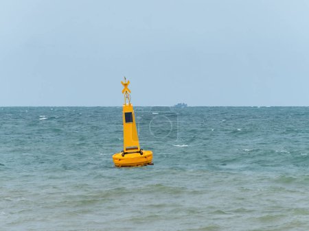 Téléchargez les photos : Bouée jaune avec une lumière solaire en mer pour marquer une zone dangereuse, dans ce cas une zone réservée aux nageurs près d'une plage à Pattaya, Thaïlande. - en image libre de droit