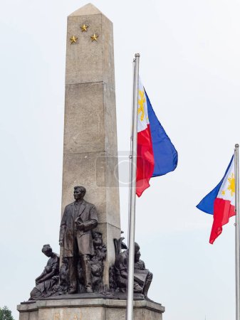 Photo for The Jose Rizal Monument and the flag of the Philippines at Rizal Park along Roxas Boulevard in Manila, Philippines. - Royalty Free Image