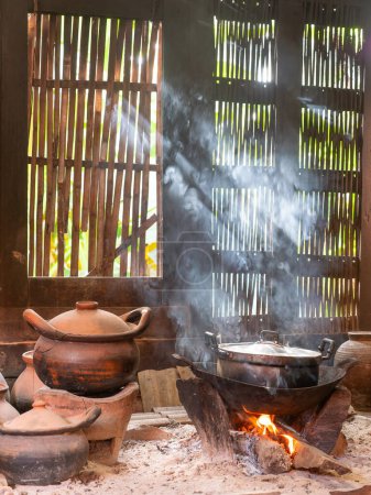 Photo for Kitchen at a traditional wooden Thai house with cooking over open flames. - Royalty Free Image