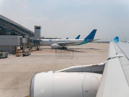 Téléchargez les photos : Jakarta, Indonésie - 21 octobre 2017 : Deux Airbus A330 dans la livrée de Garuda Indonesia, un au premier plan et un en arrière-plan, à l'aéroport international Soekarno-Hatta en attente de départ. - en image libre de droit