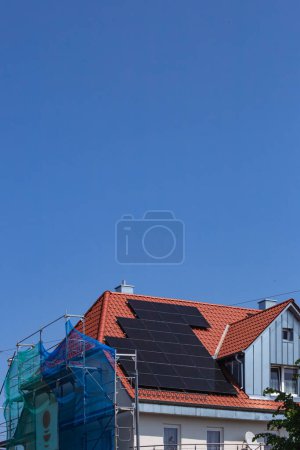 Photo for Solar panel on building roof with construction scaffold in south germany sunny spring day - Royalty Free Image