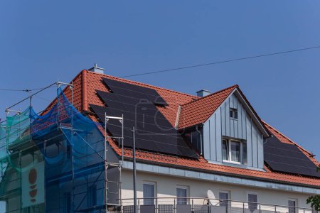 Téléchargez les photos : Panneau solaire sur le toit de la construction avec échafaudage de construction en Allemagne du Sud jour ensoleillé de printemps - en image libre de droit