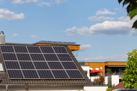 Foto de Techo del panel solar en la construcción de techo en el sur de Alemania ciudad con el cielo azul y el sol en las plantas verdes - Imagen libre de derechos