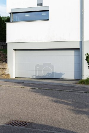 Téléchargez les photos : Garage abri sur une façade de maison moderne en Allemagne du Sud ville au soleil d'été et ciel bleu - en image libre de droit