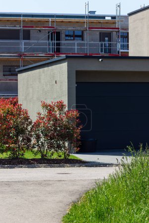Téléchargez les photos : Garage abri sur une façade de maison moderne en Allemagne du Sud ville au soleil d'été et ciel bleu - en image libre de droit