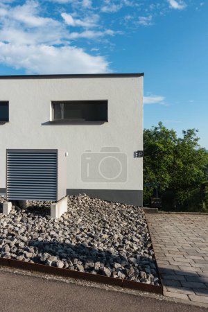 Téléchargez les photos : Pompe à chaleur dans un nouveau bâtiment avec des façades de maison modernes de l'Allemagne du Sud par une journée ensoleillée en été - en image libre de droit