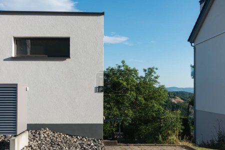 Téléchargez les photos : Pompe à chaleur dans un nouveau bâtiment avec des façades de maison modernes de l'Allemagne du Sud par une journée ensoleillée en été - en image libre de droit