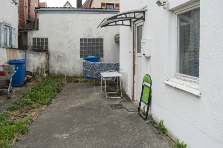 Téléchargez les photos : Patio ancien avec poubelle et mobilier à l'entrée de la maison en Allemagne du Sud - en image libre de droit