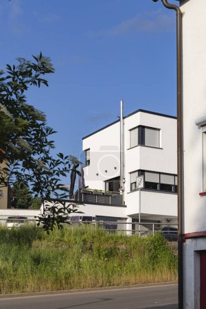 Téléchargez les photos : Maison moderne façade avec cheminée fenêtres balcon sur ciel bleu en Allemagne du sud jour d'été - en image libre de droit