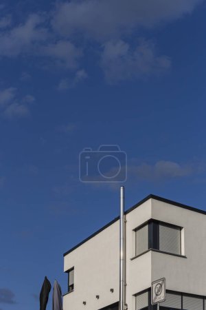Foto de Moderna fachada de la casa con ventanas de chimenea balcón en el cielo azul en el sur de Alemania día de verano - Imagen libre de derechos