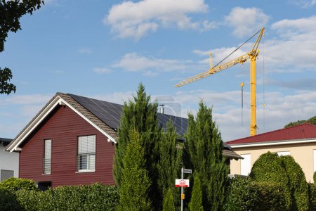 Téléchargez les photos : Façade préfabriquée de construction en bois avec panneaux solaires sur le toit en Allemagne du Sud et grue de construction - en image libre de droit