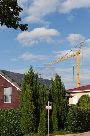 Foto de Edificio prefabricado frente a la construcción de madera con paneles solares en la azotea en el sur de Alemania y grúa de construcción - Imagen libre de derechos