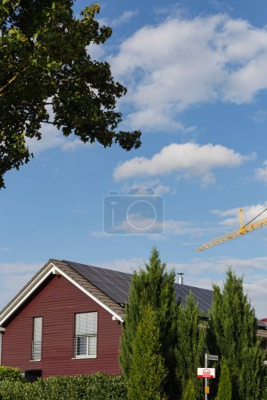 Photo for Prefabricated building front of wood construction with solar panels on rooftop in south germany  and construction crane - Royalty Free Image