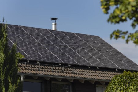 Téléchargez les photos : Nouveau bâtiment avec panneau solaire sur le toit et jardin arbuste vert dans le sud de l'Allemagne été ciel bleu jour - en image libre de droit