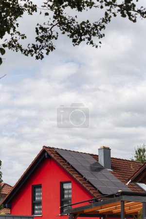 Foto de Nuevo edificio con panel solar en la azotea y fachada de casa roja con cielo nublado en el sur de Alemania nueva área de construcción - Imagen libre de derechos