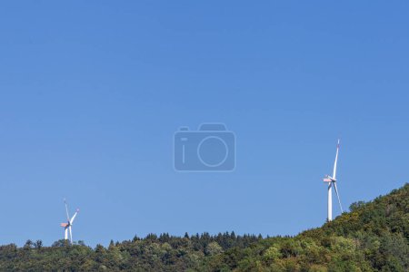 Téléchargez les photos : Éolienne dans un environnement naturel proche de la forêt verte et de la zone agricole - en image libre de droit