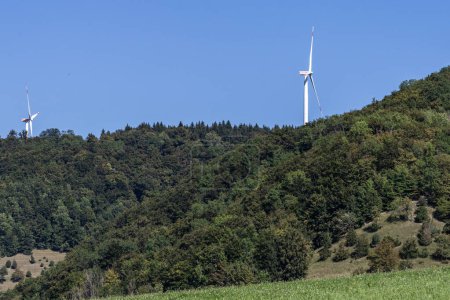 Foto de Turbina eólica en el entorno natural del paisaje cerca del bosque verde y la zona agrícola - Imagen libre de derechos