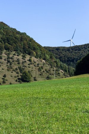 Foto de Turbina eólica en el entorno natural del paisaje cerca del bosque verde y la zona agrícola - Imagen libre de derechos