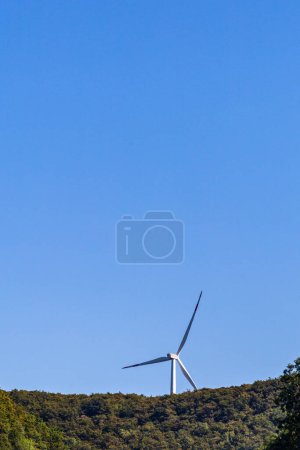 Photo for Wind turbine in natural landscape environment near green forest and agricultural area - Royalty Free Image