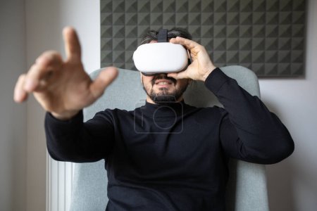 Junger Mann trägt VR-Brille und zeigt auf etwas
