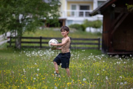 Foto de Hermoso joven jugando fútbol en un prado - Imagen libre de derechos