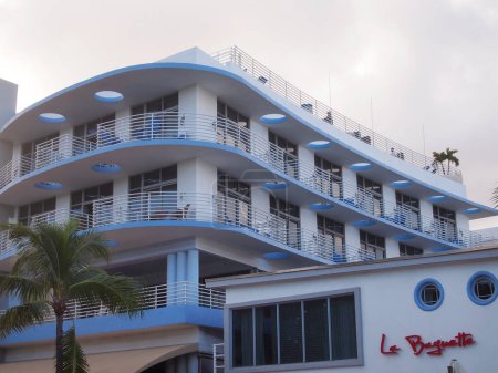 Photo for MIAMI, FLORIDA - NOVEMBER 11, 2012: Pastel blue tones, dramatic curvy architecture, and perky palm trees are some of the iconic details of a classic art deco scene on Ocean Drive in Miami, FL. - Royalty Free Image
