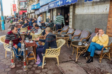 Foto de ALEXANDRIA, EGYPT - FEBRUARY 1, 2019: People in a traditional street cafe in Alexandria, Egypt - Imagen libre de derechos