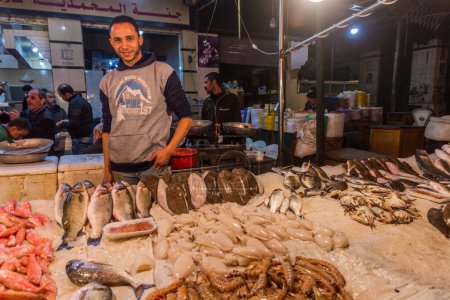 Foto de ALEXANDRIA, EGYPT - FEBRUARY 1, 2019: Evening view of a fish stall in Alexandria, Egypt - Imagen libre de derechos
