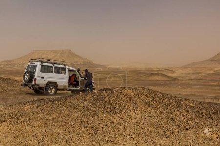 Foto de BAWITI, EGYPT - FEBRUARY 5, 2019: 4WD vehicle in a desert near Bahariya oasis, Egypt - Imagen libre de derechos