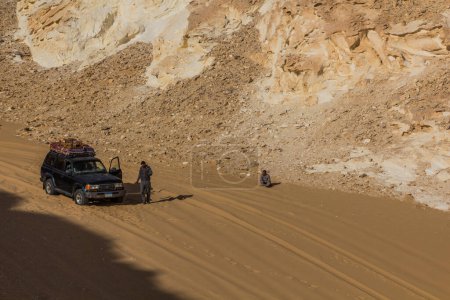 Téléchargez les photos : WHITE DESERT, EGYPT - FEBRUARY 6, 2019: Tourist vehicle in El Aqabat (Agabat) valley in the White Desert, Egypt - en image libre de droit