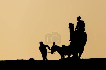Photo for Silhouettes of a donkey and camel rider at the Djoser (Zoser) funerary complex in Saqqara, Egypt - Royalty Free Image